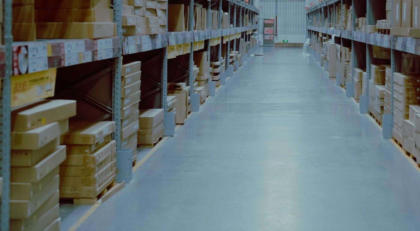 Warehouse aisle lined with racks of packed cartons in storage