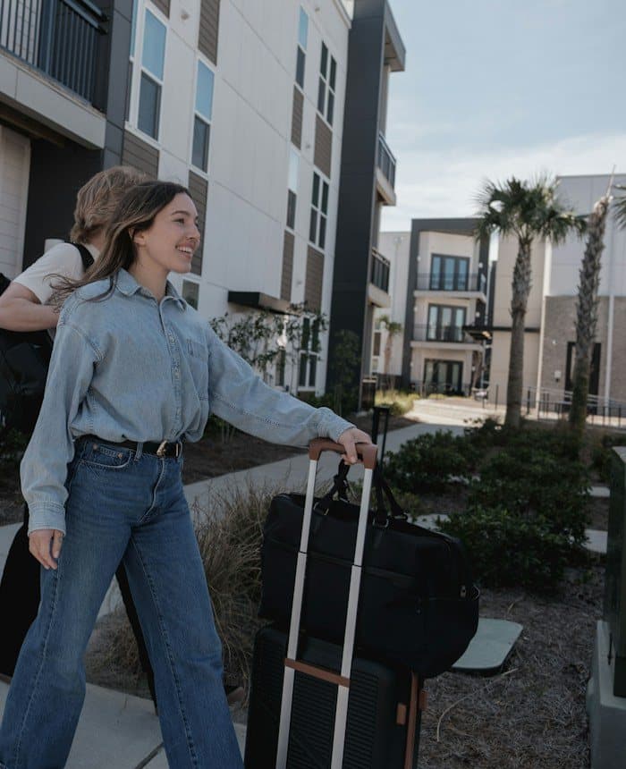 Customers carrying boxes and luggage into a new apartment